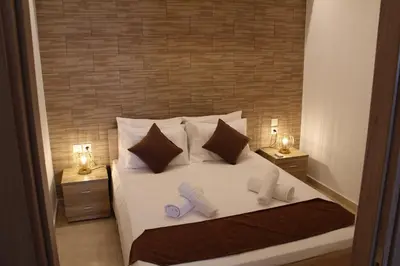 a bedroom with a white bed with two night stands at Sea Pearl Luxury Apartment in Rhodes Town