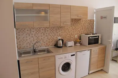 a kitchen with a washing machine and a microwave at Sea Pearl Luxury Apartment in Rhodes Town