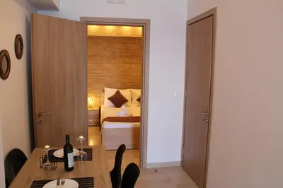 a bedroom with a bed and a table with a bottle of wine at Sea Pearl Luxury Apartment in Rhodes Town