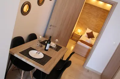 a dining room table with a bottle of wine on it at Sea Pearl Luxury Apartment in Rhodes Town