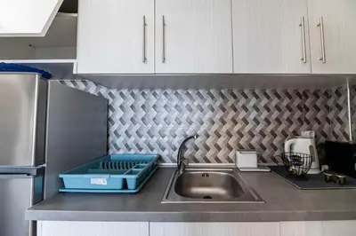 a kitchen sink with a blue box on the counter at Aperanto Galazio Apartment in Archangelos