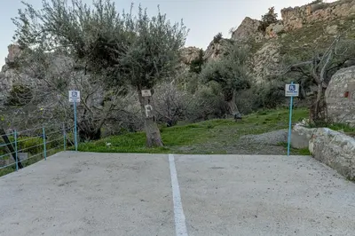 a parking lot with two signs in front of a mountain at Aperanto Galazio Apartment in Archangelos