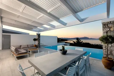 a patio with a table and chairs and a couch at Villa Phos with swimming pool in Lindos in Líndos