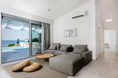 a living room with a couch and a table at Villa Phos with swimming pool in Lindos in Líndos
