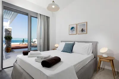 a bedroom with a large bed with a view of the ocean at Villa Crystal with swimming pool in Lindos in Líndos