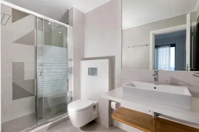 a white bathroom with a toilet and a sink at Villa Crystal with swimming pool in Lindos in Líndos