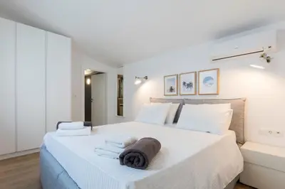 a white bedroom with a large bed with towels on it at Villa Emerald with swimming pool in Lindos in Líndos
