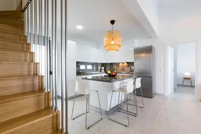 a kitchen with a white table and white chairs at Villa Emerald with swimming pool in Lindos in Líndos