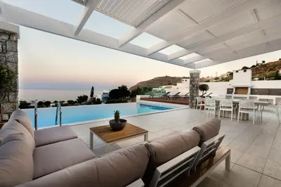 a living room with a couch and a table at Villa Estella with pool & jacuzzi in Lindos in Líndos