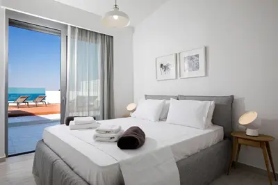 a bedroom with a bed with a view of the ocean at Villa Estella with pool & jacuzzi in Lindos in Líndos