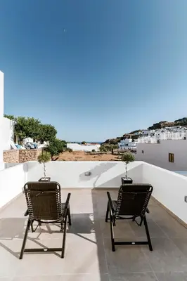 two chairs sitting on top of a roof with a view at Lindos Calmare Suites in Líndos
