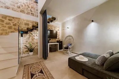 a living room with a couch and a tv at Lindos Calmare Suites in Líndos