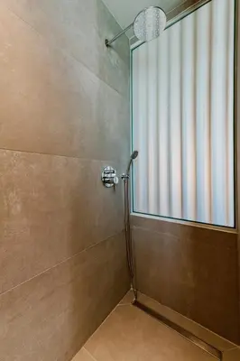 a shower with a glass door in a bathroom at Lindos Calmare Suites in Líndos