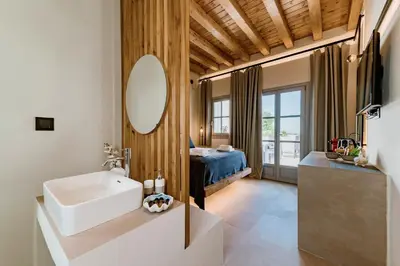 a bathroom with a sink and a mirror and a bed at Lindos Calmare Suites in Líndos