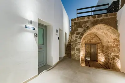a hallway with a door and a brick wall at Lindos Calmare Suites in Líndos