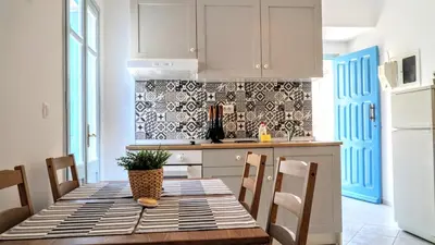 a kitchen with a table and chairs in a kitchen at Ritzi Apartment in Symi