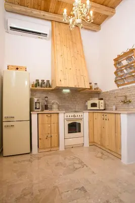 a kitchen with wooden cabinets and a white refrigerator at White Rose in Kalithies