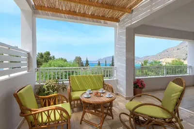 a balcony with chairs and a table and a table at Villa Evelyn in Pefki Rhodes