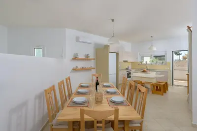 a kitchen and dining room with a wooden table and chairs at Villa Evelyn in Pefki Rhodes
