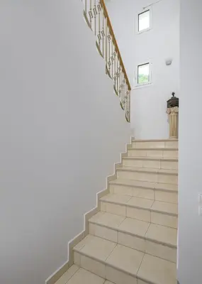 a staircase in a house with white walls and wooden floors at Villa Evelyn in Pefki Rhodes