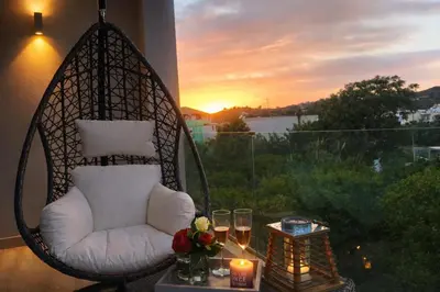 a swing chair sitting on a balcony with a sunset at Villa Almihauss - Adults Only in Afantou