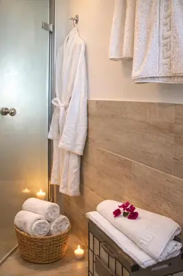 a bathroom with towels and a shower with candles at Villa Almihauss - Adults Only in Afantou