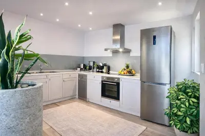 a kitchen with white cabinets and a stainless steel refrigerator at Villa Almihauss - Adults Only in Afantou