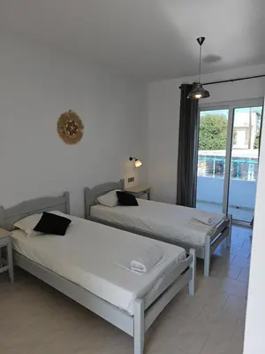 two beds in a room with a window at Lisabeth Apartments in Faliraki