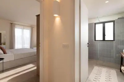 a bedroom with a bed and a bathroom with a shower at South Key Villa in Pefki Rhodes