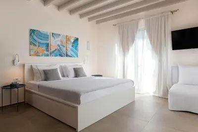 a white bedroom with a large bed and a window at South Key Villa in Pefki Rhodes