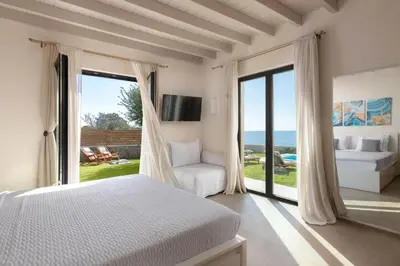 a bedroom with a bed and a view of the ocean at South Key Villa in Pefki Rhodes