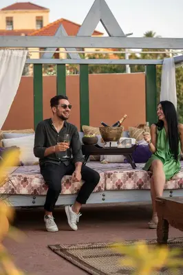 a man and a woman sitting on a bench with drinks at DECAN Concept Boutique Estate in Rhodes Town