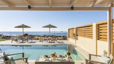 a pool with chairs and a table with food on it at Kiotari Akti Beachfront Villas in Gennadi