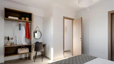 a bedroom with white walls and a mirror and a bed at Kiotari Akti Beachfront Villas in Gennadi