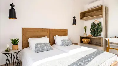 a bedroom with a bed with white sheets and pillows at Kiotari Akti Beachfront Villas in Gennadi