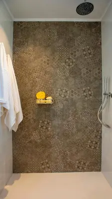 a bathroom with a shower with a brown wall at Kiotari Akti Beachfront Villas in Gennadi