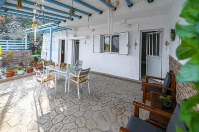 a patio with a table and chairs in a house at Springs Petronas Apartment in Archangelos