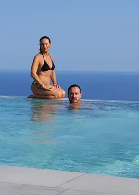 a woman and man in the water in a swimming pool at Bouganville Bed & Breakfast Stegna in Archangelos