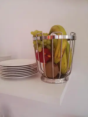 a basket of fruit on a table with plates at Bouganville Bed & Breakfast Stegna in Archangelos