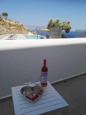a bottle of wine and two glasses on a table at Bouganville Bed & Breakfast Stegna in Archangelos