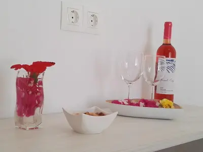 a table with a bottle of wine and two glasses at Bouganville Bed & Breakfast Stegna in Archangelos