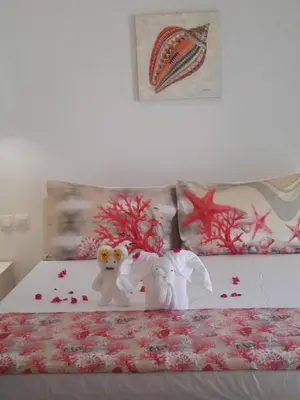 two stuffed animals sitting on top of a bed at Bouganville Bed & Breakfast Stegna in Archangelos