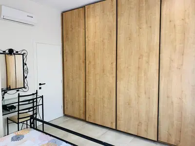 a large wooden closet in a room with a bed at Apartment Marla in Rhodes Town