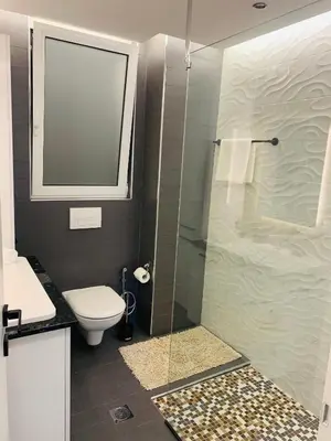 a bathroom with a toilet and a glass shower at Apartment Marla in Rhodes Town