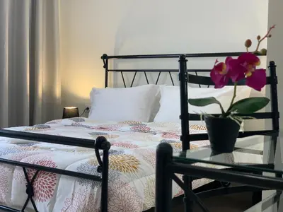 a bed with a glass table with a flower on it at Apartment Marla in Rhodes Town