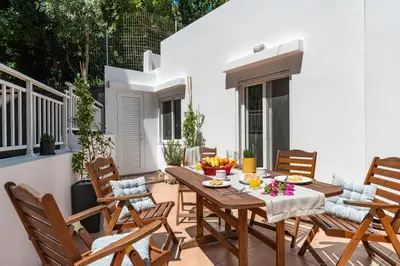 a patio with a wooden table and chairs at Oasis in the Heart of Rhodes, next to Old Town, near Beaches - Haven Home in Rhodes Town