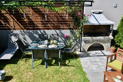 a patio with a table and chairs and a grill at Dionysus seaside villa in Ialyssos