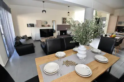 a dining room and living room with a table and chairs at Dionysus seaside villa in Ialyssos