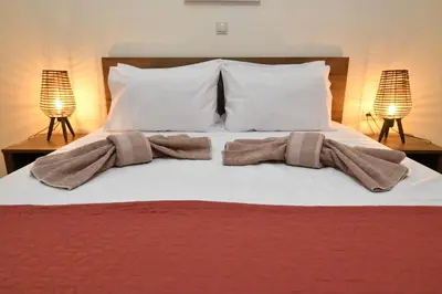 a bed with white pillows and towels on it at Dionysus seaside villa in Ialyssos