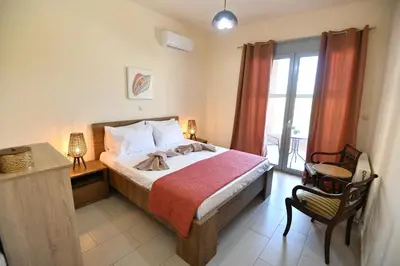 a bedroom with a bed and a chair and a window at Dionysus seaside villa in Ialyssos